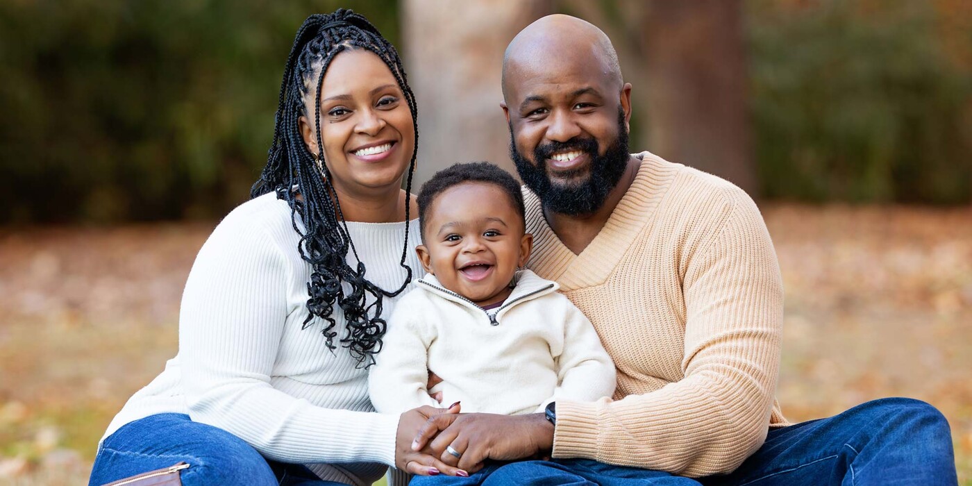 Arlene Brown smiles for a family photo with her husband, Richard, and their son Andrew. Photo courtesy of Faith V Photography Arlene Brown poses outside with her husband and baby