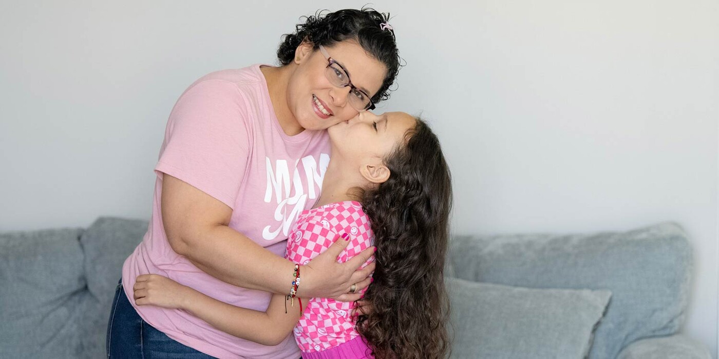 Eliana Vera González sonríe mientras su hija la abraza en su casa en Morrisville, NC. Eliana Vera González sonríe mientras su hija la abraza en su casa en Morrisville, NC.