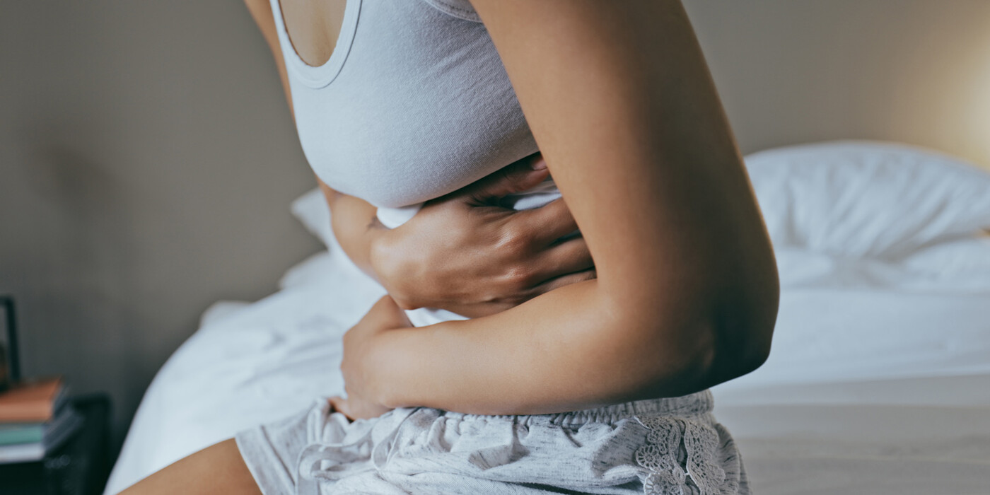 A woman wraps her arms around her abdomen