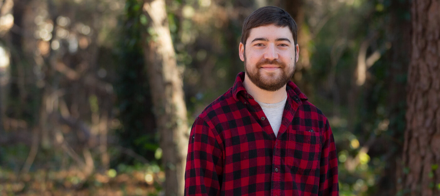 John Welch, 34, smiles in Durham, NC. John Welch stands outside
