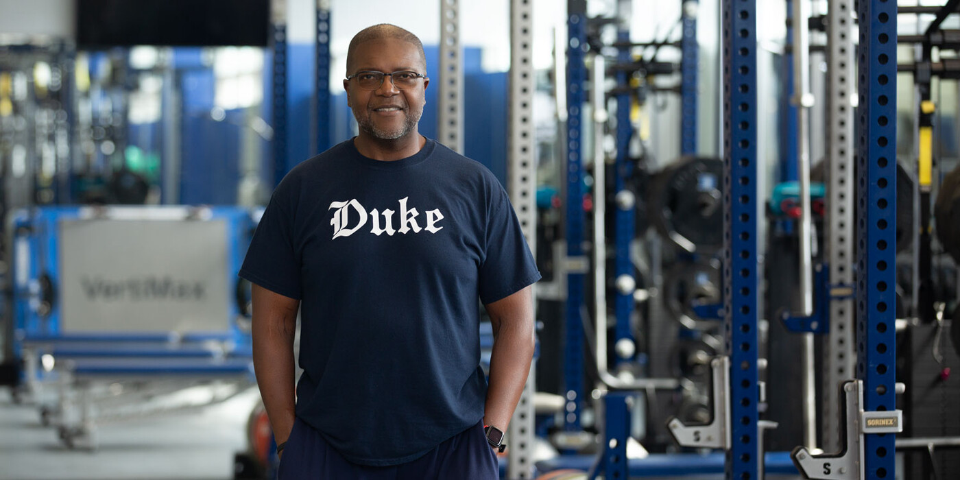William Stephens stands in Duke University’s basketball weight room where he trains Blue Devils players. William Stephens smiles in a Duke weight room