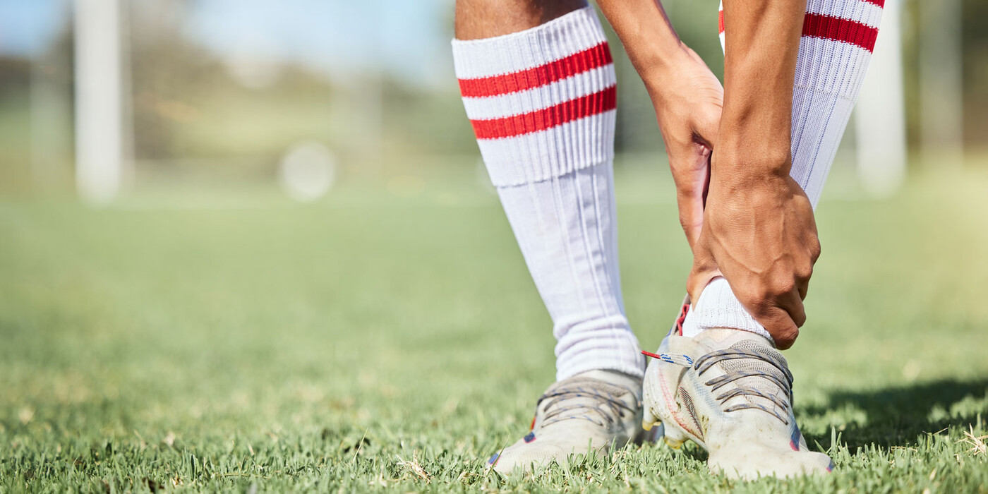 A soccer player holds his ankle