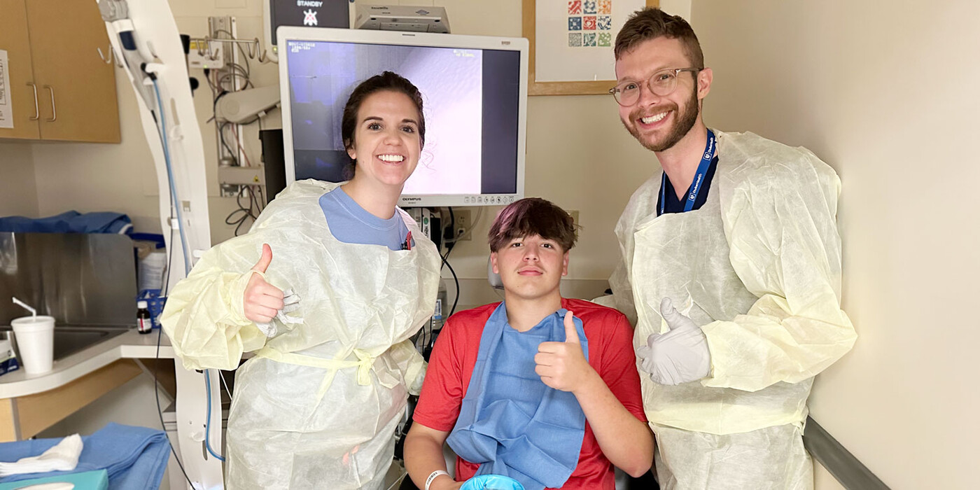 From left, Katharine Newton, Richard Best and John Lyles, MD, celebrate Duke Health’s first transnasal endoscopy. Two medical team members stand beside Richard Best in a procedure room. They are all giving a thumbs up.