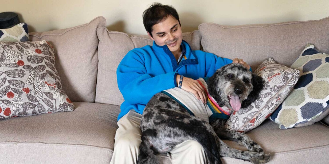Tyler Farley pets his dog, Stormy, at his home in Raleigh, NC. Tyler and his dog cuddle together on a couch